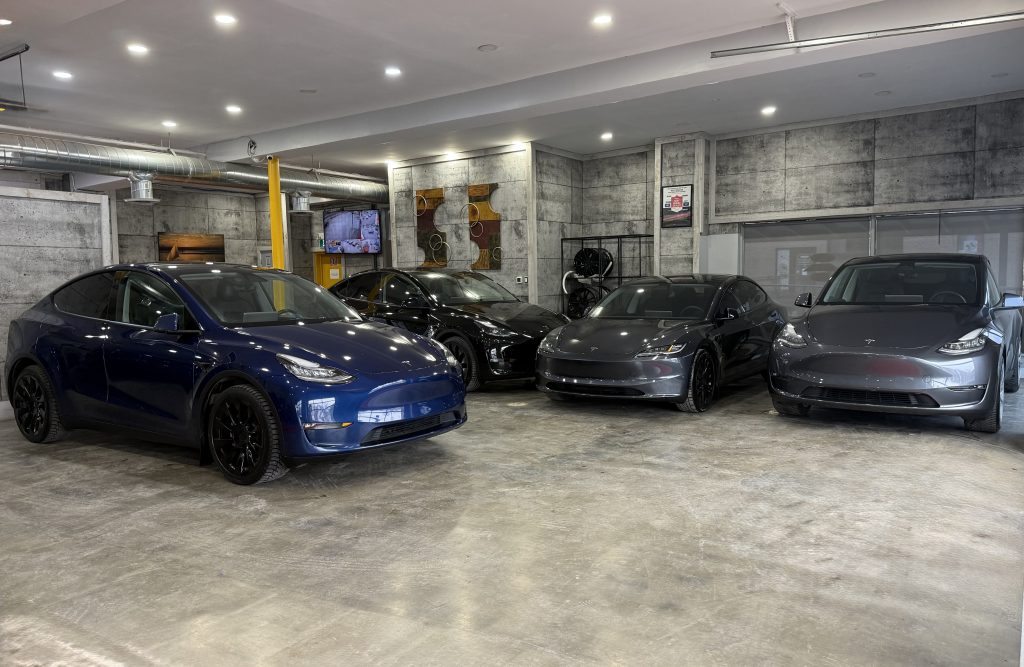 Used Tesla vehicles available in Canada showroom Used Tesla vehicles displayed inside a dealership showroom in Canada including Model 3 and Model Y