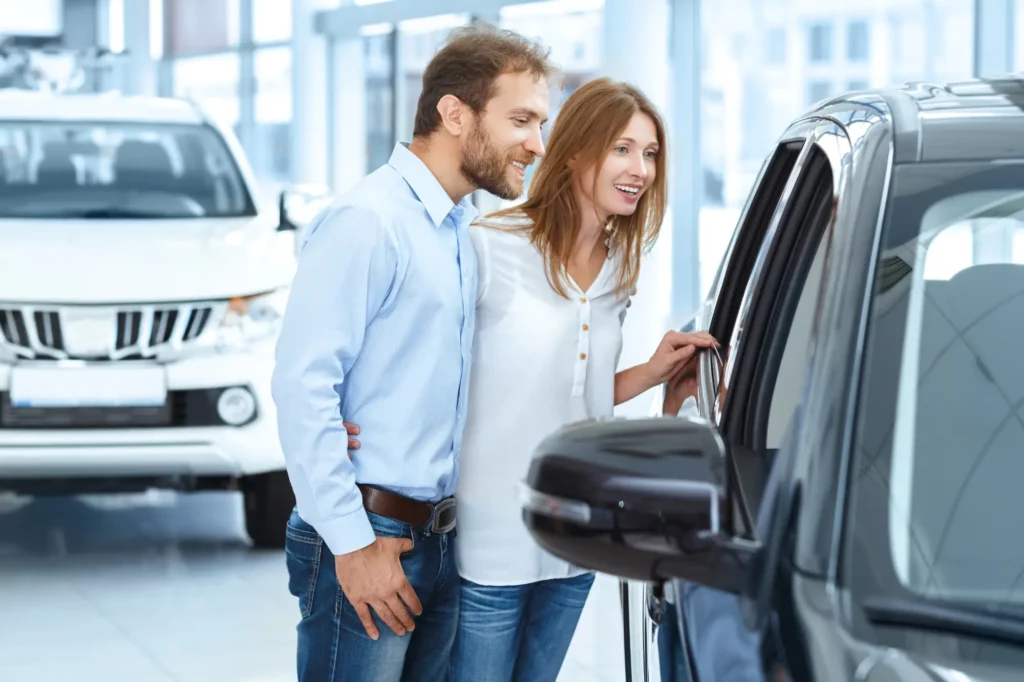 Couple standing beside a white SUV with the door open