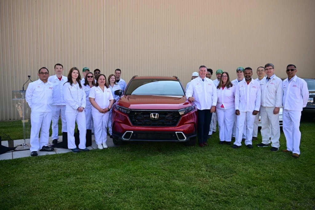 Factory workers around a red Honda