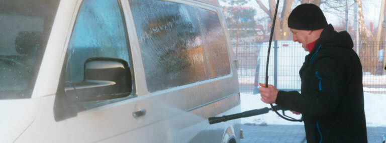 Man pressure washing van