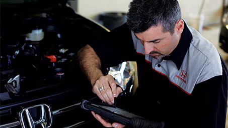 Technician changing transmission fluid