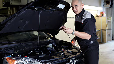 Technician changing engine oil