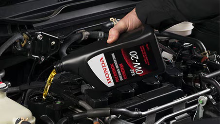 Technician changing motor oil