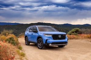 Light blue 2023 honda pilot on dirt road