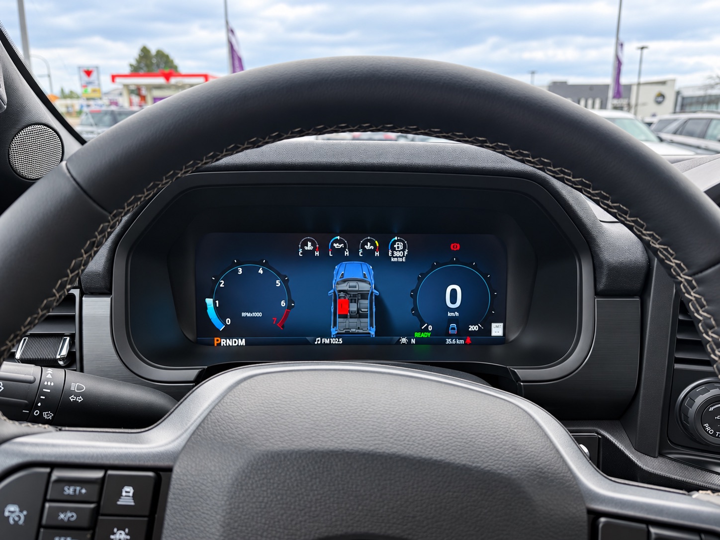 Ford F-150 PowerBoost Hybrid digital instrument cluster seen through the steering wheel