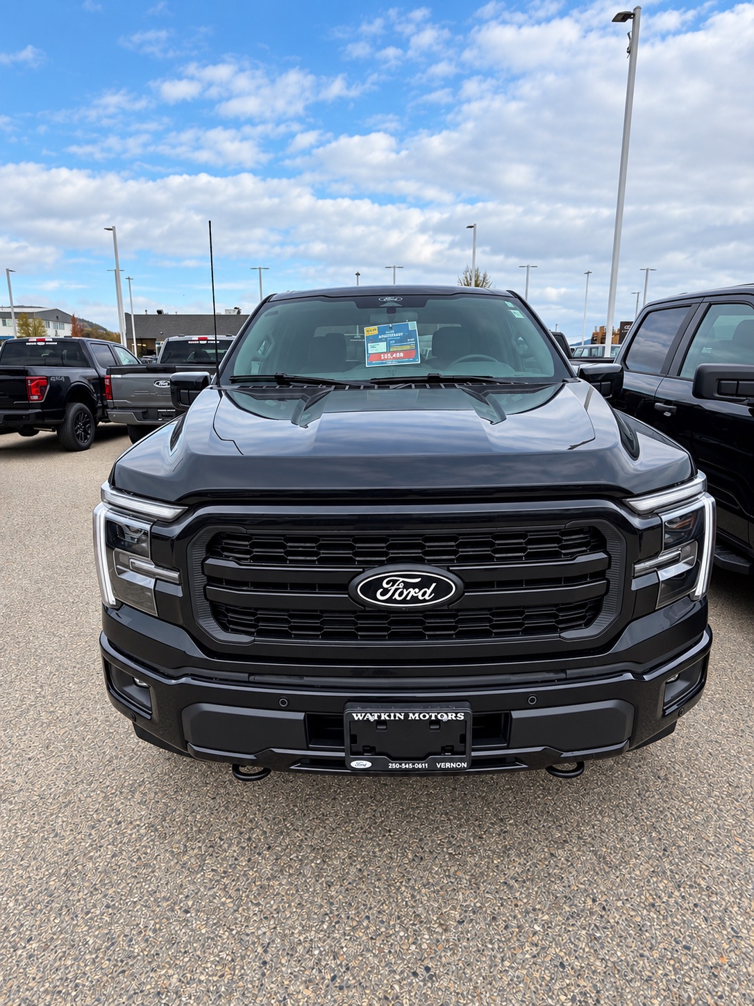 Black Ford F-150 PowerBoost Hybrid, front view, on the Watkin Motors Ford lot in Vernon, BC