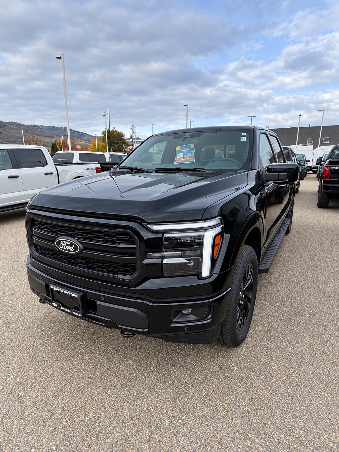 Black Ford F-150 PowerBoost Hybrid, three-quarter front view, at Watkin Motors Ford in Vernon