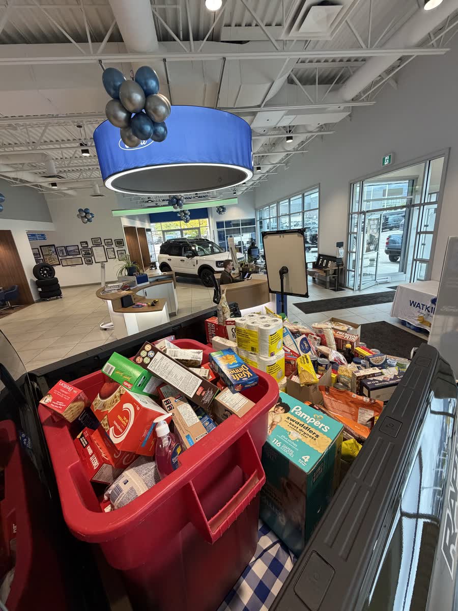 Salvation Army bin and a truck bed filled with donations in the Watkin Motors Ford showroom