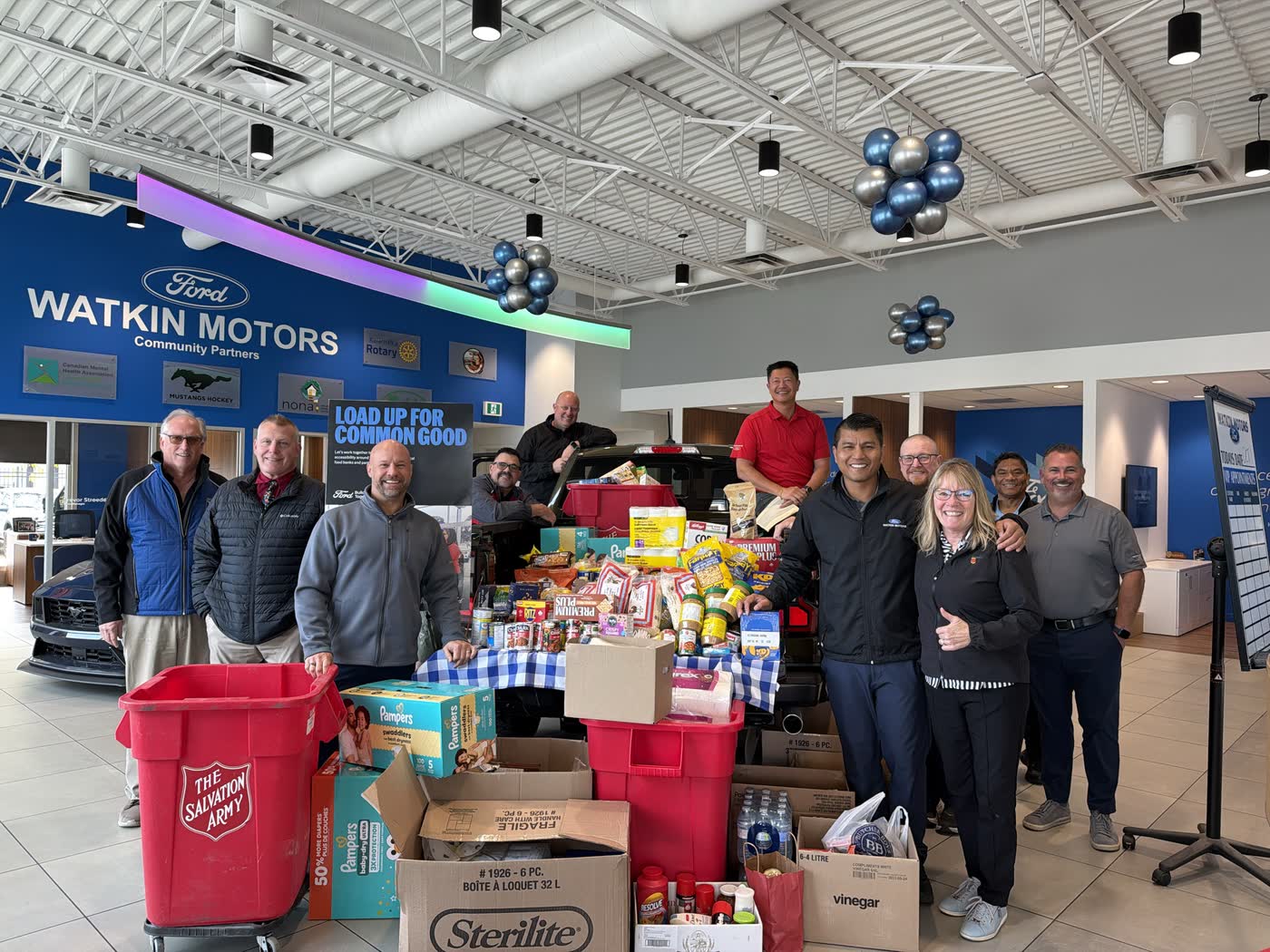 Watkin Motors Ford team with the food drive donations and Salvation Army bins in the showroom