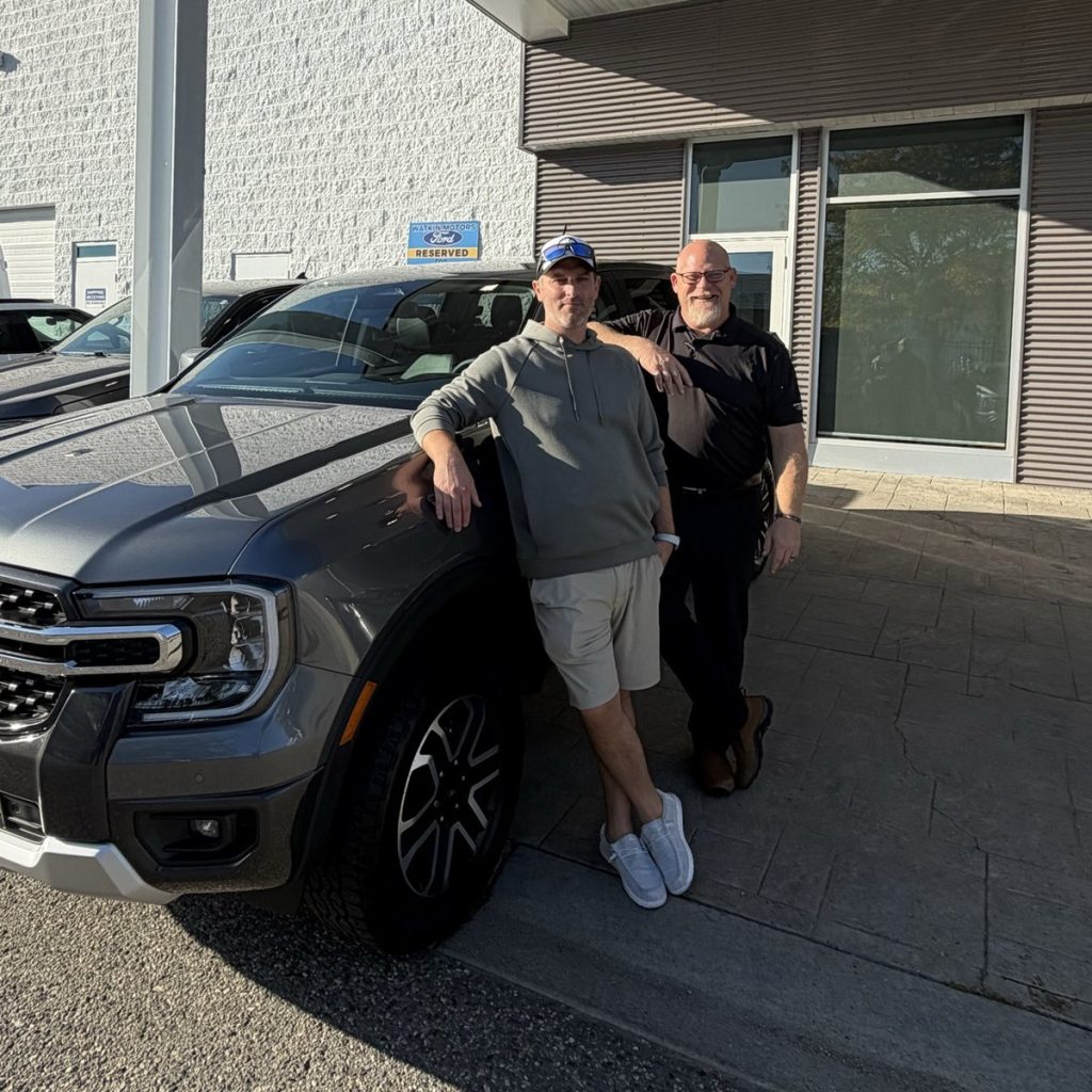Customer with his new Ford pickup and salesperson at Watkin Motors in Vernon