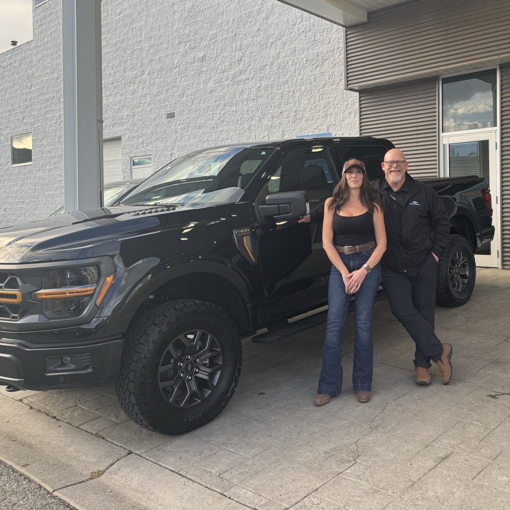 New Ford owner with her salesperson beside a new pickup at Watkin Motors