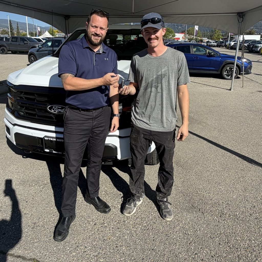 Customer receiving the keys to his new Ford truck at Watkin Motors in Vernon