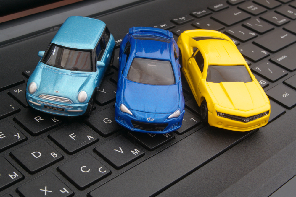 three toy cars on a keyboard