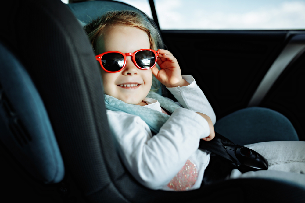 infant in car with red sunglasses