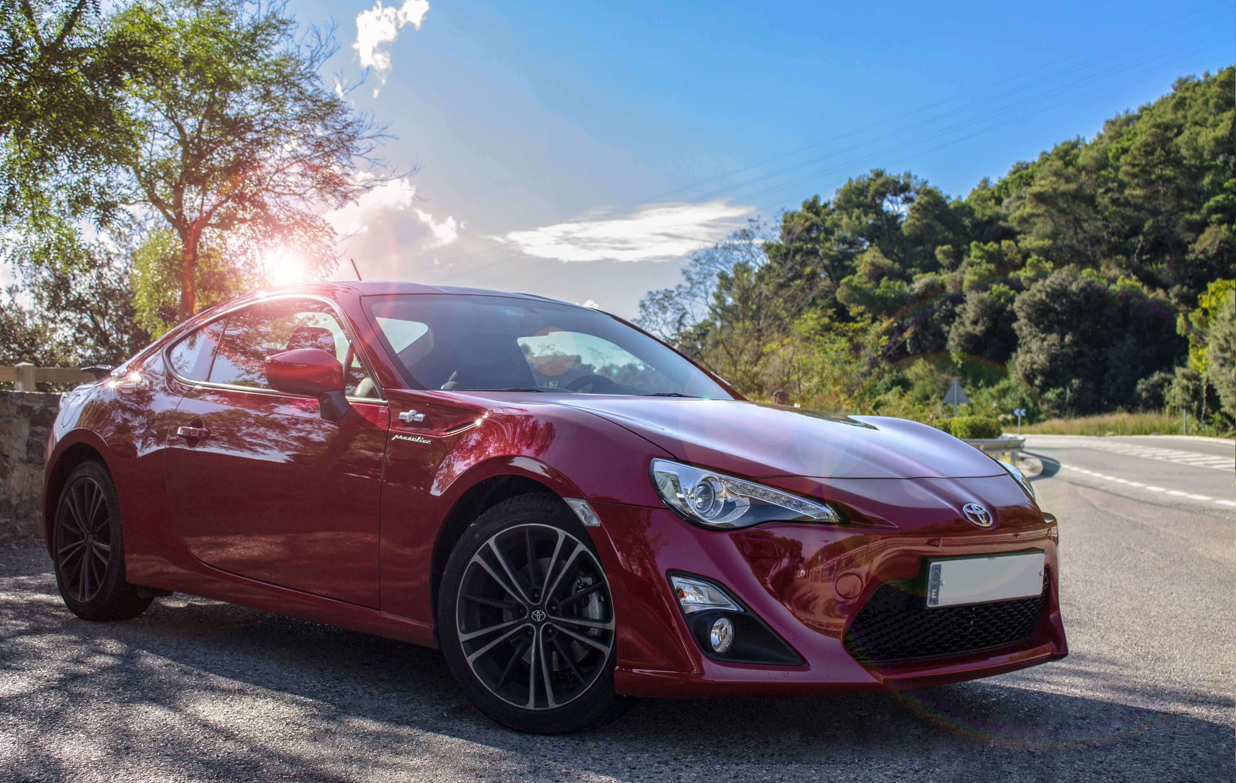 Detailed red Toyota 86 in the sun on public roads.