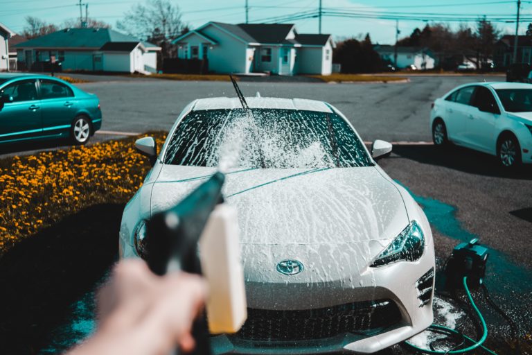 Washing white car on driveway