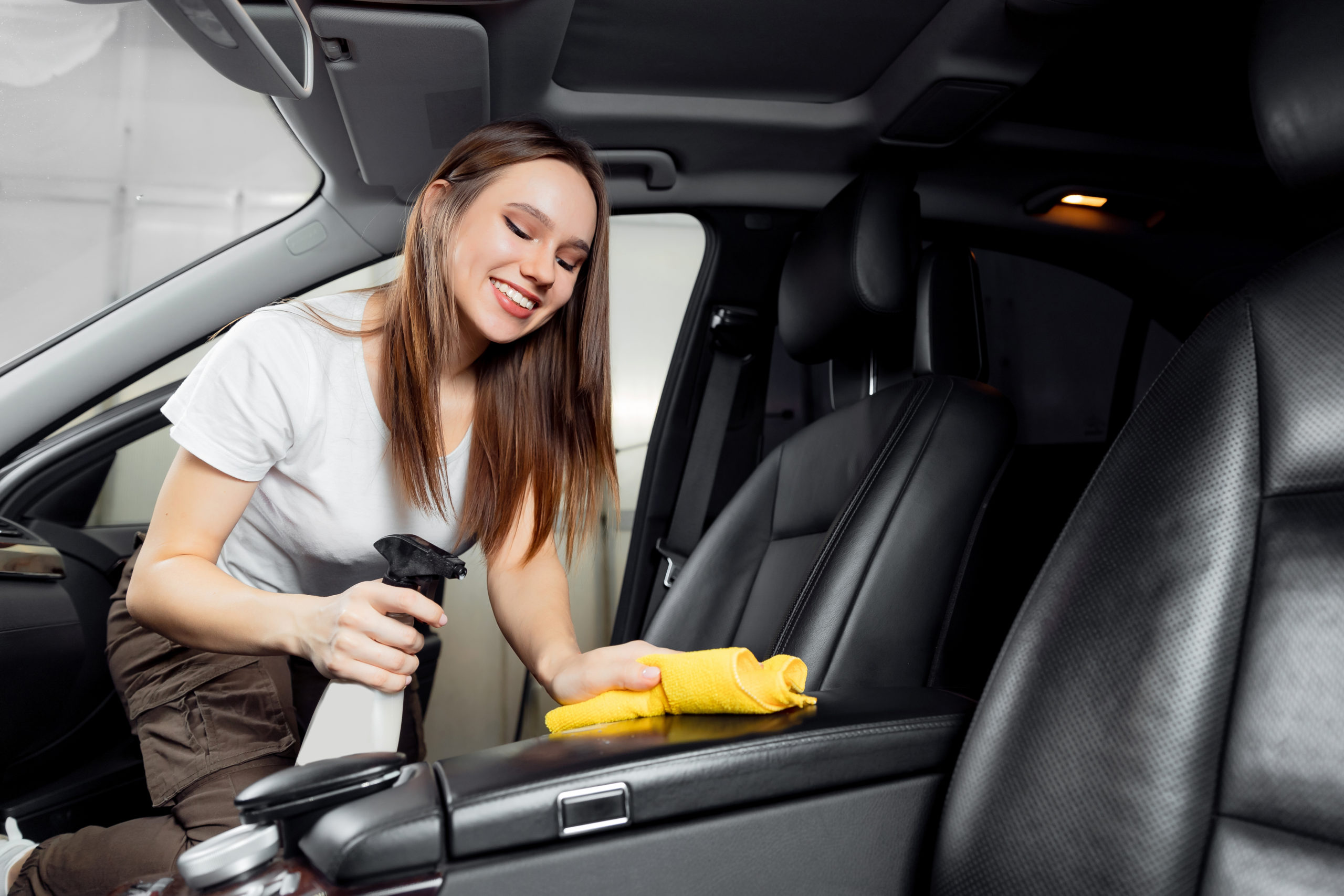 woman cleaning car interior leather