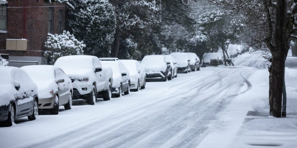 row of cars sitting idle for too long in the winter